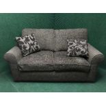 A three piece suite upholstered in brown fabric