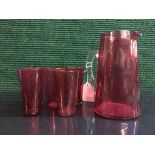 An early twentieth century cranberry glass jug together with five beakers (6)