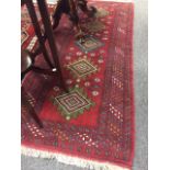 A fringed Persian rug on red ground