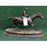 A bronze figure of a horse and jockey