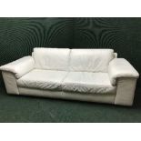 A cream leather three seater settee