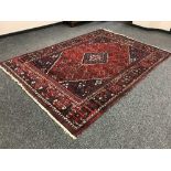 A fringed Persian carpet on red ground