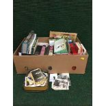 A box of books, vintage postcards and monochrome photographs,
