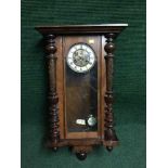 An Edwardian mahogany wall clock with pendulum and key