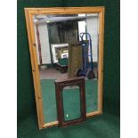 A large pine framed bevelled mirror together with a mahogany mirror