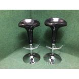 A pair of black and chrome gas lift bar stools