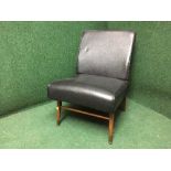 A mid twentieth century black vinyl chair on teak legs