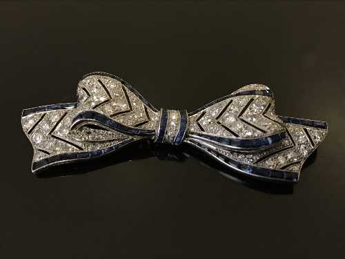 A fine white gold, diamond and sapphire set bow brooch,