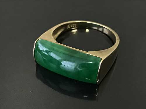 A jade set ring, the oblong form jade weighing an estimated 6.31 carats, on yellow gold shank, 5.