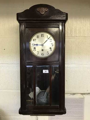 An early twentieth century wall clock with glazed panel door