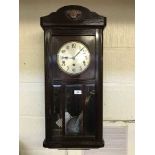 An early twentieth century wall clock with glazed panel door