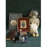 A crate of collectables including porcelain doll, old camera, carved box,