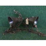 Two cast metal bells on wall brackets (2)