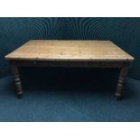 A large pine kitchen table fitted three drawers