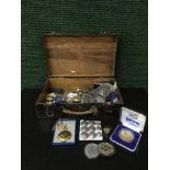 An old wooden box containing badges, collectables, coins,