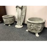 A pair of ornate cherub planters on paw feet