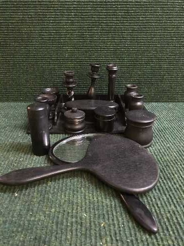 A box of ebony dressing table set, hand brushes, lidded pots,