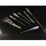 Four silver handled button hooks, scissors,