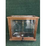 A set of jeweler's scales in a glass case