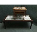A Danish mahogany tiled topped coffee table and a nest of teak tiled topped tables