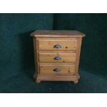 A pine three drawer bedside chest