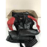 A box of motor cycle leathers with boots and gloves