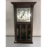 A late Victorian oak wall clock with pendulum and key