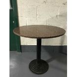A circular marble topped pedestal cafe table