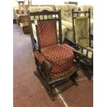 A mahogany American style rocking chair upholstered in red fabric together with matching footstool