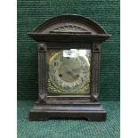 A late nineteenth century oak fourteen day strike mantle clock with brass face