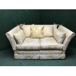 A three piece lounge suite upholstered in golden floral fabric comprising of three seater settee,
