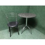 A circular marble pedestal cafe style table and chair