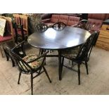 A circular Ercol drop leaf table together with five chairs