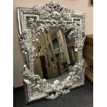 An ornate silvered floral mirror