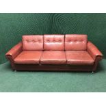 A red buttoned leather three seater settee with matching armchair