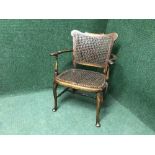 An antique mahogany child's bergere armchair