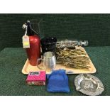 A tray of brass cutlery service, HMS victory ship in bottle, soda syphon,