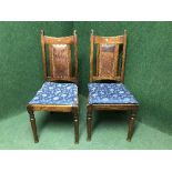 A pair of late Victorian oak dining chairs inset with leather panel