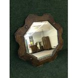 An early twentieth century shaped oak framed bevelled mirror