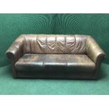 A brown leather three seater settee