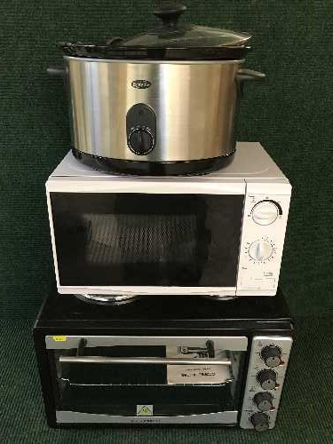 An Andrew James table oven together with a Brevelle slow cooker and a microwave