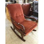 A mid twentieth cenutry Parker Knoll rocking chair upholstered in red fabric