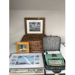 A wicker picnic basket together with a cased Petite deluxe junior typewriter together with a framed