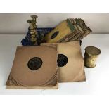 A box of 78's, pair of candlesticks, brass shell casing,