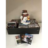 A box of assorted DVDs and a Disney cookie jar