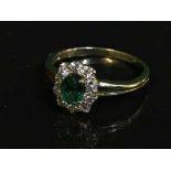 An 18ct gold diamond and emerald cluster ring, (retail receipt £2500).