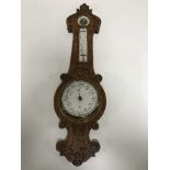 A carved oak barometer