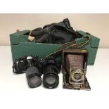 An antique camera, modern cameras by Nikon,