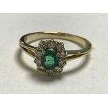 An 18ct gold diamond and emerald cluster ring, (retail receipt £2500).
