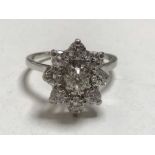 A diamond cluster ring in platinum, central stone approximately 0.